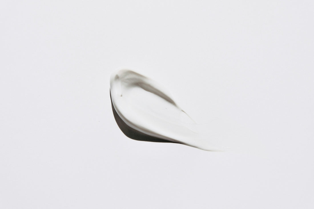 A smear of white cosmetic cream on a plain white background