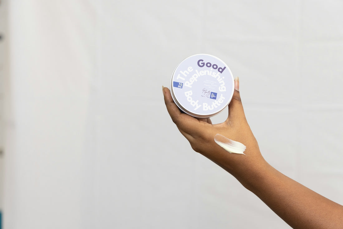 Hand holding a jar with cream and smeared on skin