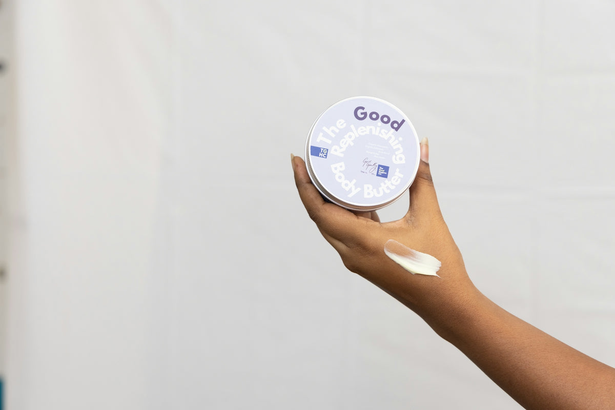 Hand holding a jar with cream and smeared on skin